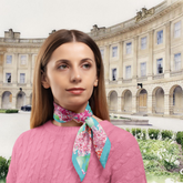 Woman wearing a floral silk twill scarf in front of a large building - The Crescent